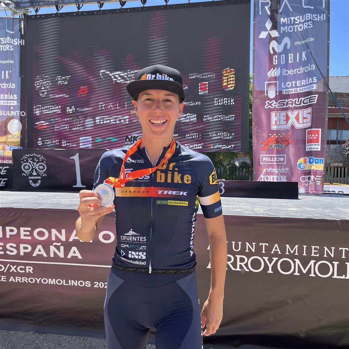 Ana Gay showing her medal in front of the podium of the Spanish Championships