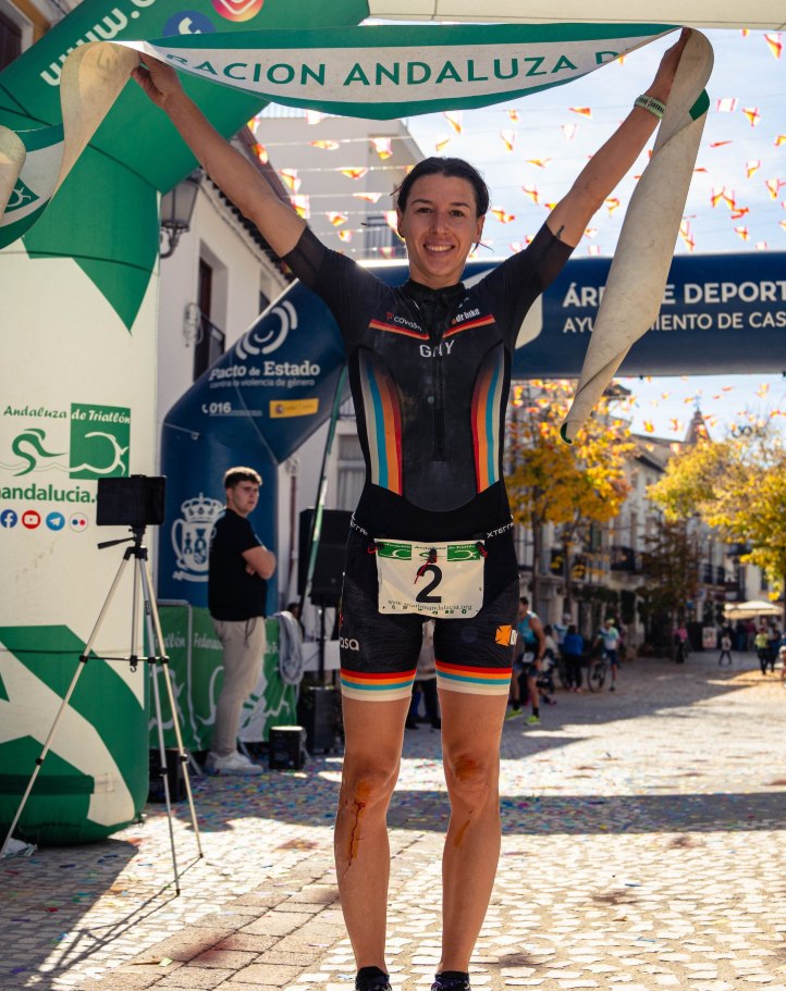 Ana Gay holding the finish tape above her head